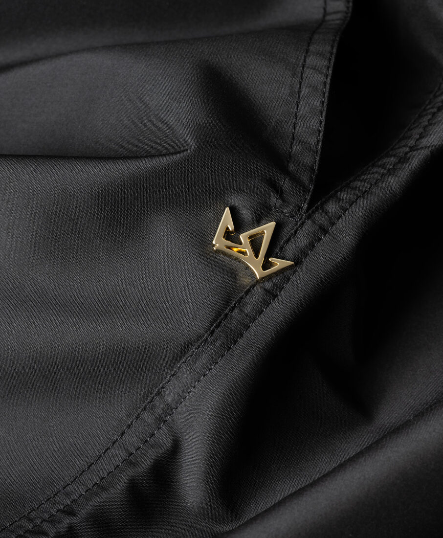 Detail of the Noor Milano gold logo on black fabric, professional photography in Italy by Inlet Studio