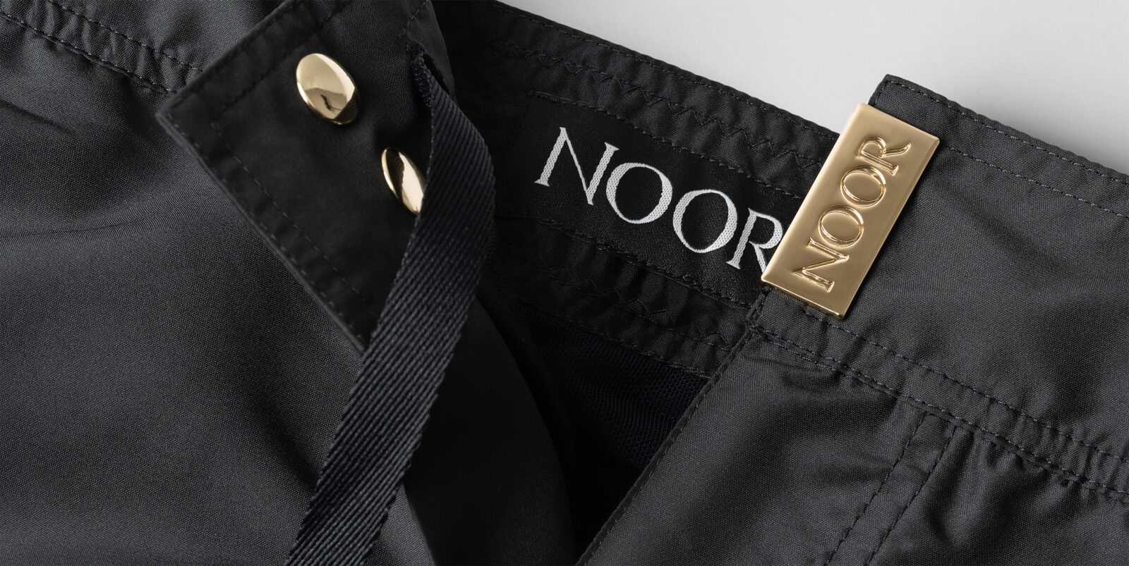 Luxury swimwear photography detail: Noor garment with gold finishes, photographed in Italy by Inlet Studio.